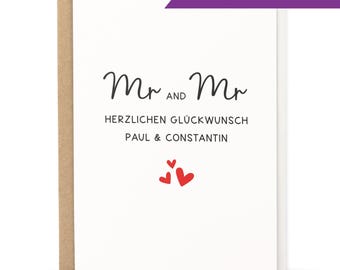 May include: A white card with black text that reads "Mr. and Mr. Herzlichen Glückwunsch Paul & Constantin" with three red hearts.