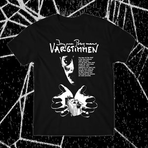 May include: Black t-shirt with a white graphic print of a man's face and hands holding a small box. The text "Jesus Bergmann Vargtimmen" is printed above the image. The text "The hour of the wolf is the hour between night and dawn. It is the hour when most people are asleep, when nightmares are real and the deepest fears are banished by the hour when the sleepers are haunted by the deepest fears and when powers are most powerful." is printed below the image.
