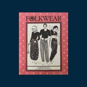 May include: A rectangular sewing pattern envelope titled FOLKWEAR with a pink border featuring white floral accents. The center illustration depicts three figures wearing various styles of Sarouelles pants from Turkey, Africa, and India.