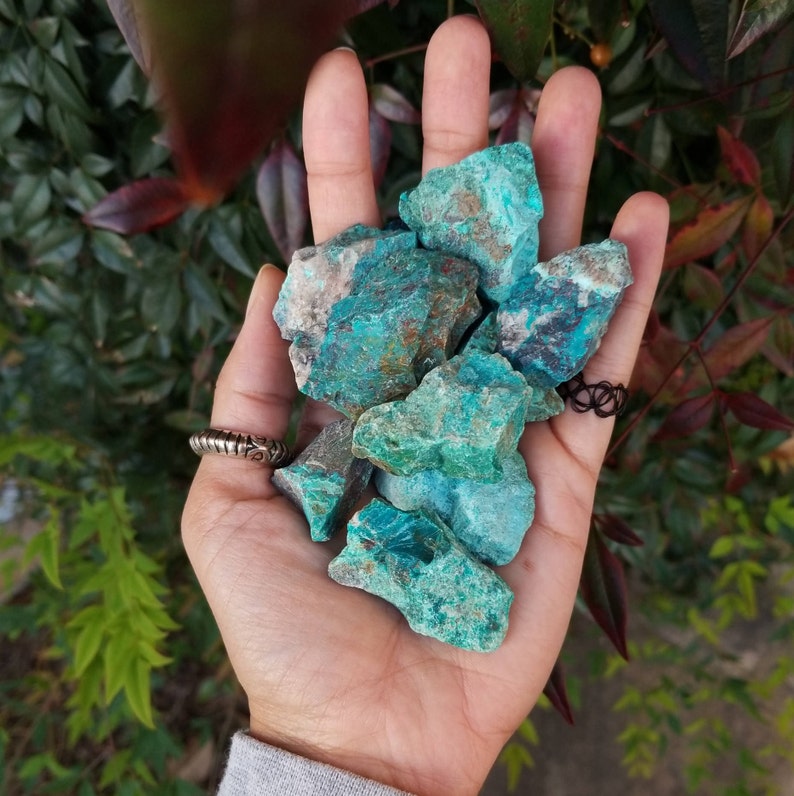 A palm full of rough chunks of vibrant blue stones.