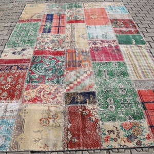 May include: A patchwork rug with a variety of colors and patterns, including red, green, blue, and beige. The rug is made of different pieces of fabric that have been sewn together.