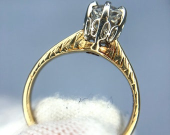 Puede incluir: Un anillo de oro con un diamante engastado en un engaste de oro blanco. El anillo tiene una banda texturizada.