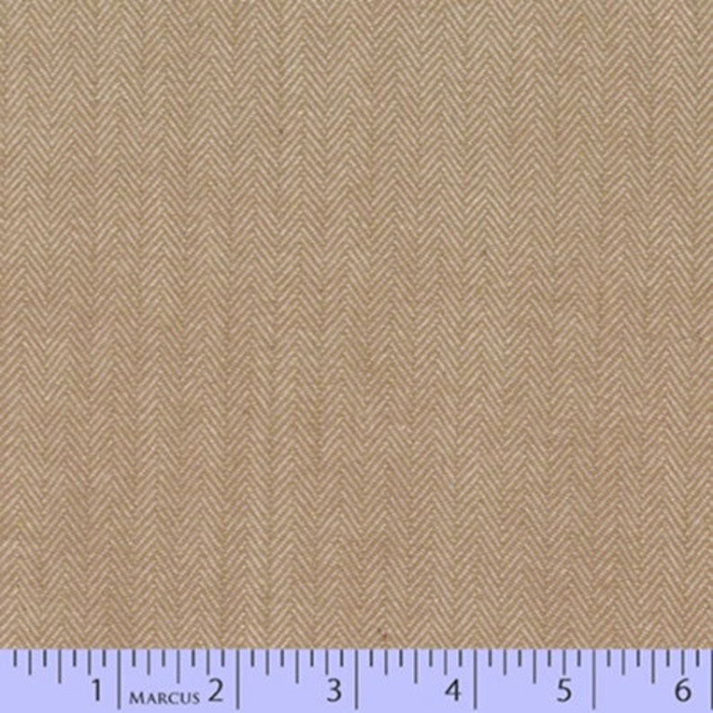 May include: Close-up of tan herringbone fabric. The fabric has a repeating V-shaped pattern. A ruler with inch measurements is at the bottom of the image. The fabric is a neutral colour and could be used for various sewing projects.