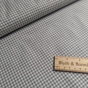 Puede incluir: Tela de cuadros vichy gris y blanco con una regla que dice "Blyth & Bonnie" en texto negro.