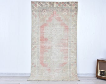 Puede incluir: Una alfombra vintage con un esquema de color rosa y crema descolorido. La alfombra tiene un patrón floral tradicional con un medallón central.
