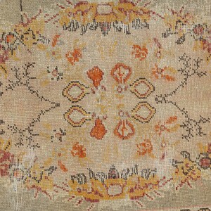 Puede incluir: Una alfombra vintage con fondo beige y un dise&ntilde;o central de medall&oacute;n. El medall&oacute;n presenta intrincados patrones florales en tonos naranja, rojo y negro.