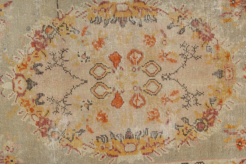 Puede incluir: Una alfombra vintage con fondo beige y un dise&ntilde;o central de medall&oacute;n. El medall&oacute;n presenta intrincados patrones florales en tonos naranja, rojo y negro.