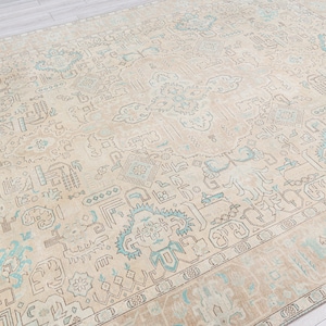 May include: A vintage rug with a beige background and a light blue and brown geometric pattern.