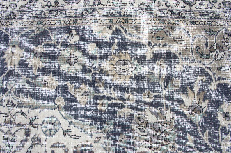 May include: A vintage rug with a blue and white floral pattern. The rug has a distressed look and is made of a woven material.
