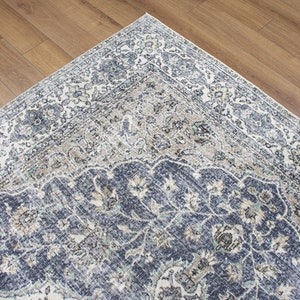 May include: A blue and cream patterned rug with a traditional design. The rug has a detailed floral pattern with a central medallion.