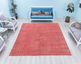 May include: A red vintage rug with a distressed look, placed in a living room setting with white furniture and a light blue sofa.