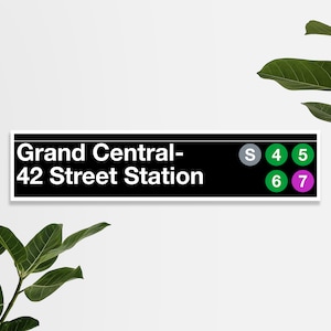 May include: Black and white sign with the text "Grand Central - 42 Street Station" in white. The sign has a row of colored circles with the letters "S", "4", "5", "6", and "7" in white.