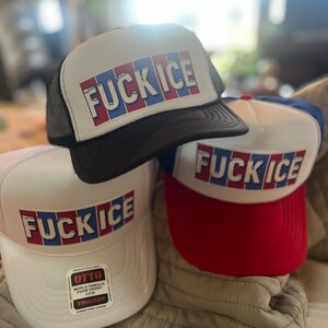 May include: Three trucker hats with the text "FUCK ICE" in red, white, and blue block letters. One hat is black, one is white with a red brim, and one is white with a black mesh back.
