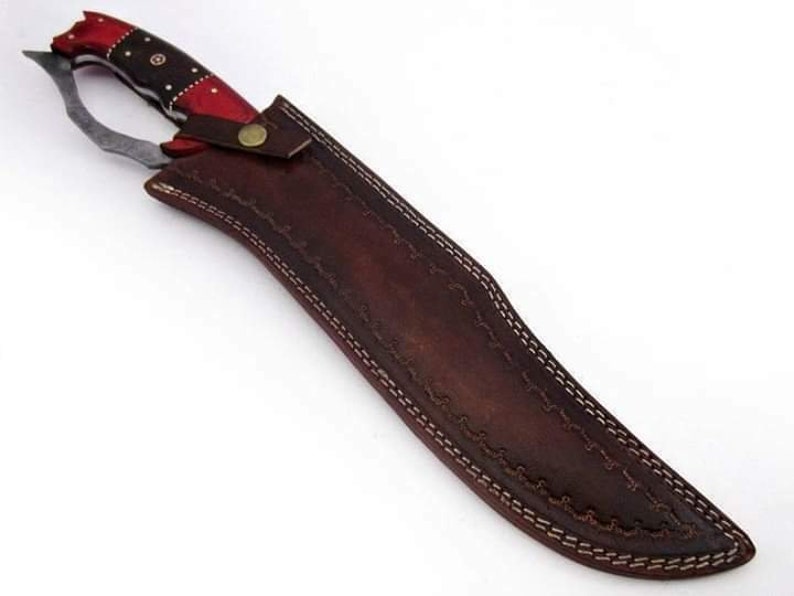 May include: A brown leather sheath with a decorative stitch pattern and a red and black handle knife.