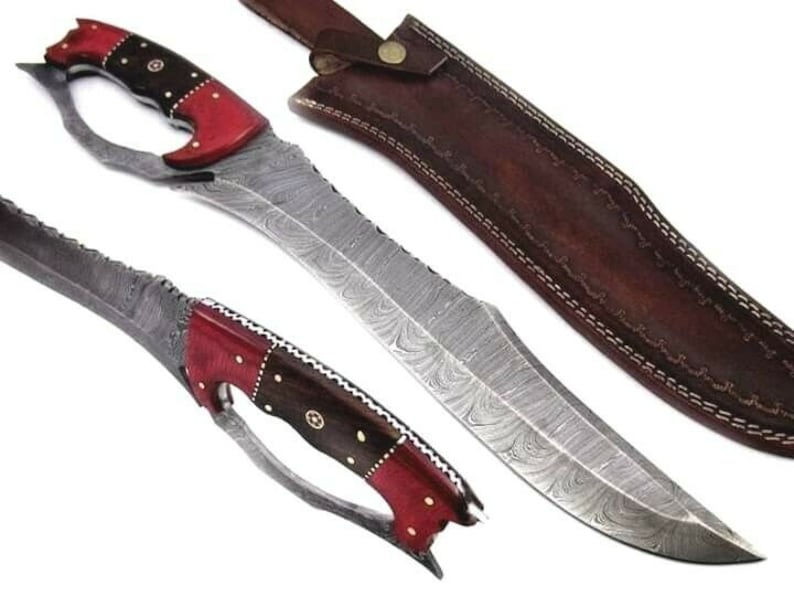 May include: A Damascus steel knife with a red and black handle and a leather sheath. The blade has a wavy pattern and the handle has a unique design.