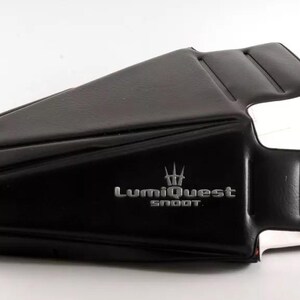 May include: Black leather camera lens hood with the text "LumiQuest Snoot" in silver lettering.