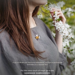 a woman standing in front of a tree with white flowers