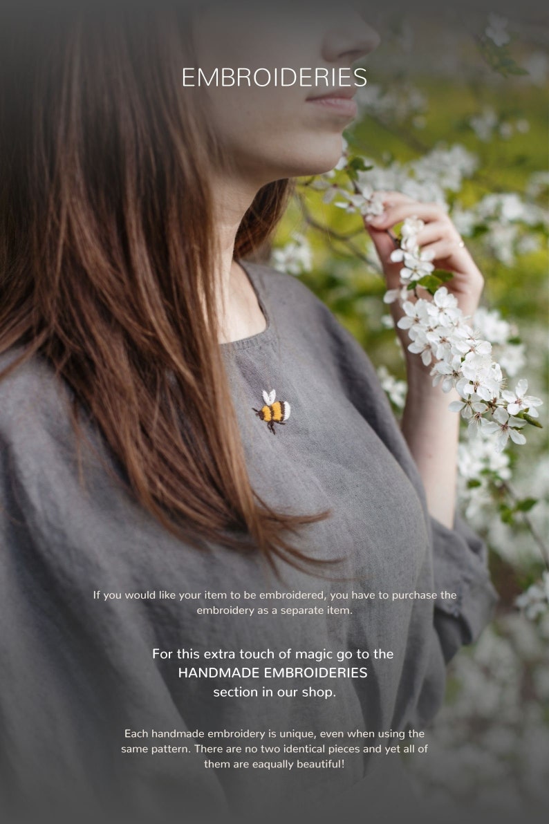 a woman standing in front of a tree with white flowers