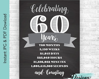 May include: A black and white chalkboard sign with the text "Celebrating 60 Years" in a decorative font. The sign also includes a list of time units in years, months, weeks, days, hours, minutes, and seconds, with the final line reading "and Counting". The sign is decorated with a gray ribbon and the text "Designs by Moonstruck Media" in a blue and green watercolor font.