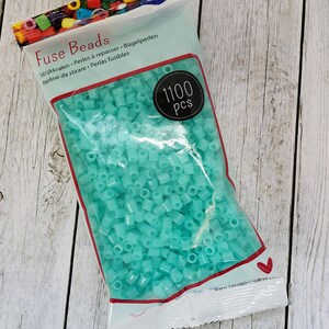 May include: A bag of 1100 turquoise fuse beads. The bag is labeled "Fuse Beads" and has the text "Strijkkralen, Perles &agrave; repasser, B&uuml;gelperlen, Perline da stirare, Perlas fusibles" on it.