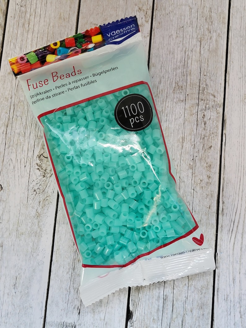 May include: A bag of 1100 turquoise fuse beads. The bag is labeled "Fuse Beads" and has the text "Strijkkralen, Perles &agrave; repasser, B&uuml;gelperlen, Perline da stirare, Perlas fusibles" on it.
