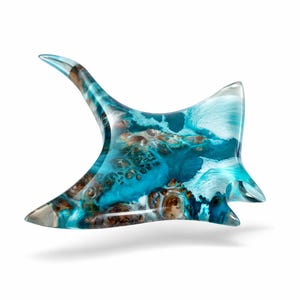 Può includere: Scultura decorativa in resina a forma di manta. La scultura presenta una miscela di tonalità blu, turchese e marrone, che ricordano le onde dell'oceano. L'apertura alare è di circa 25 cm.