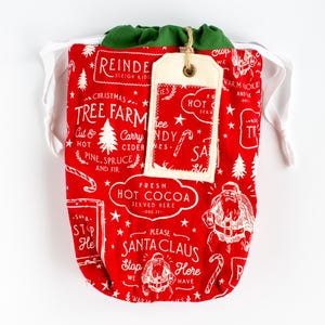 Bolsa de regalo de tela con lazo navideño clásico y etiqueta de regalo reutilizable fácil de limpiar de Papá Noel con cacao / Finney & Roo Sustainable Gifting