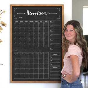 May include: A large, black chalkboard calendar with a wooden frame. The calendar is divided into a monthly grid with space for notes. The name "Harrison" is written at the top. Includes a "Menu" and "To Do" section.