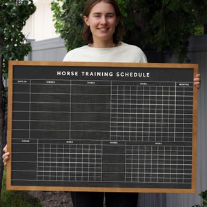 May include: A black chalkboard with a wooden frame, labeled "Horse Training Schedule". The chalkboard is divided into sections for date, owner, horse, rides, and months. It is a helpful tool for organizing horse training.
