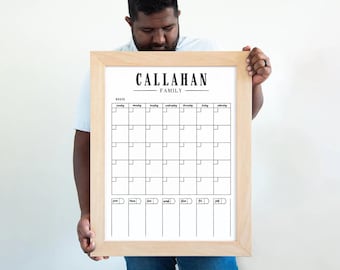 May include: A white framed calendar with the text "CALLAHAN FAMILY" at the top. The calendar has a grid for each day of the week, with spaces for notes below.