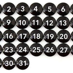 May include: Thirty-one black round buttons with white numbers from 1 to 31.