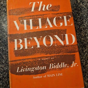 May include: An orange book cover with the title "The Village Beyond" in white, with brown brushstroke accents. The author's name, Livingston Biddle, Jr., is also displayed.