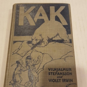 Puede incluir: Una cubierta de libro vintage con el título "KAK" en letras grandes y en negrita. La cubierta presenta una ilustración en blanco y negro de un oso polar y dos personas en un paisaje nevado. El nombre del autor es Vilhjalmur Stefansson y Violet Irwin.
