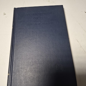 Könnte beinhalten: Ein marineblaues Hardcover-Buch mit dem Titel "Applied Mechanics - Statics" von Horner R. Hudson. Das Buch hat goldene Akzente auf dem Buchrücken und ein dezentes geprägtes Emblem auf dem Einband.