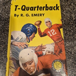 Pode incluir: Capa de livro vintage intitulada "T-Quarterback" de R. G. Emery. A capa apresenta ilustrações de jogadores de futebol americano em ação, com um jogador de uniforme vermelho lançando uma bola. O livro faz parte da série "Famous Sports Stories".