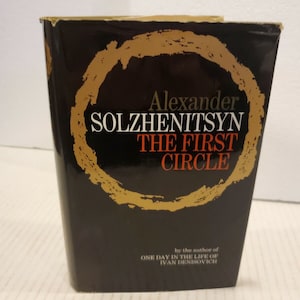 Puede incluir: Una cubierta de libro negra con un círculo dorado y el título "Alexander Solzhenitsyn El Primer Círculo" en texto blanco. El libro es del autor de "Un día en la vida de Iván Denisovich."