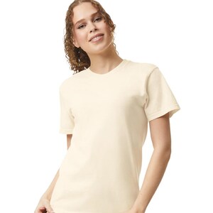 Op de afbeelding: Een cr&egrave;mekleurig T-shirt met korte mouwen. Het shirt heeft een ronde hals en een relaxte pasvorm. Het model draagt het shirt en glimlacht. De achtergrond is effen wit. Het shirt is gemaakt van een zacht, comfortabel materiaal.