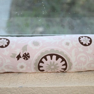 May include: A pink and brown patterned fabric with a repeating design of circles and swirls. The fabric is soft and has a subtle sheen.