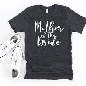a t - shirt that says mother of the bride next to a pair of sneakers