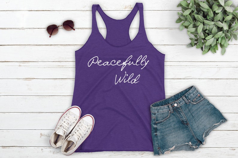 May include: Purple tank top with the text "Peacefully Wild" in white script.