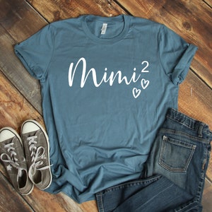 a t - shirt with the word mnnj on it next to a pair