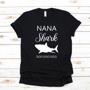 a black t - shirt with a shark on it