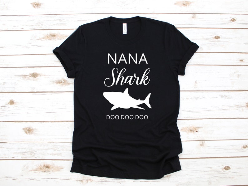 a black t - shirt with a shark on it