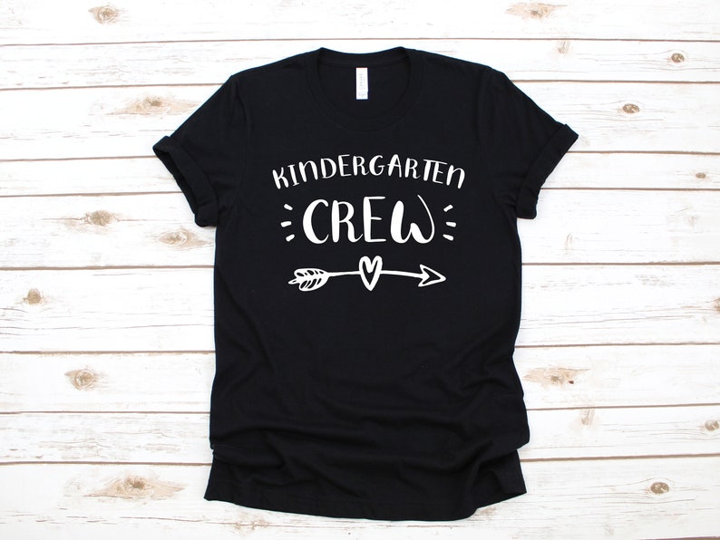 May include: Black t-shirt with white text that says "Kindergarten Crew" with an arrow and heart graphic.