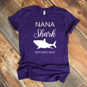 a purple shirt with a white shark on it