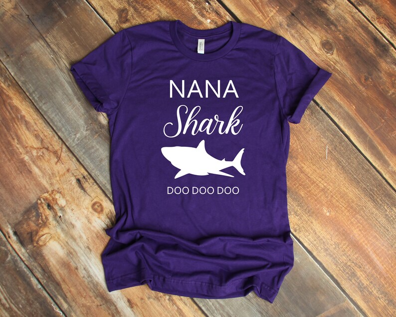 a purple shirt with a white shark on it