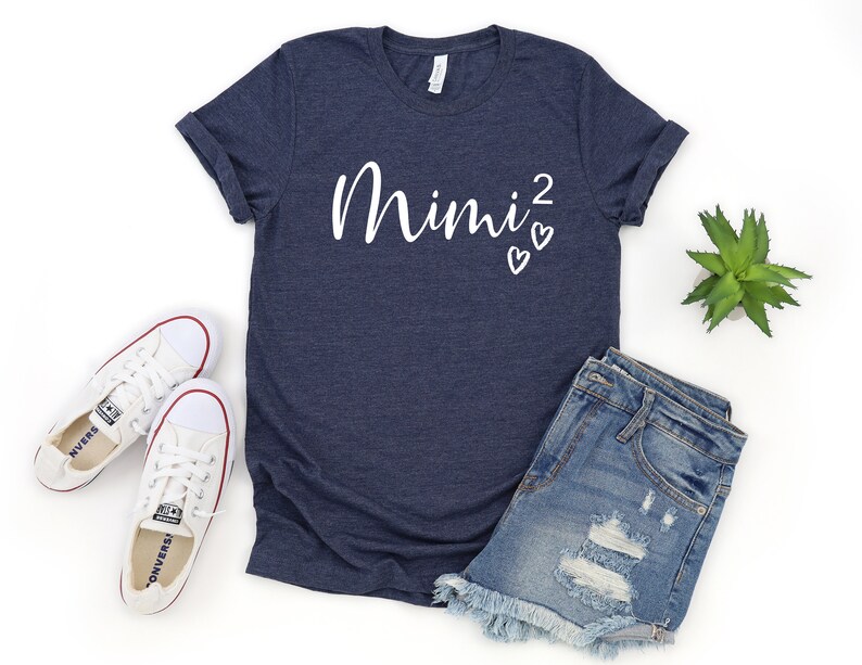 a t - shirt with the word mimi on it next to a pair of shorts