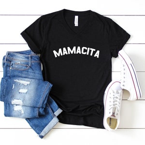 a black shirt that says mamacita next to a pair of jeans