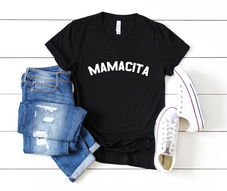a black shirt that says mamacita next to a pair of jeans