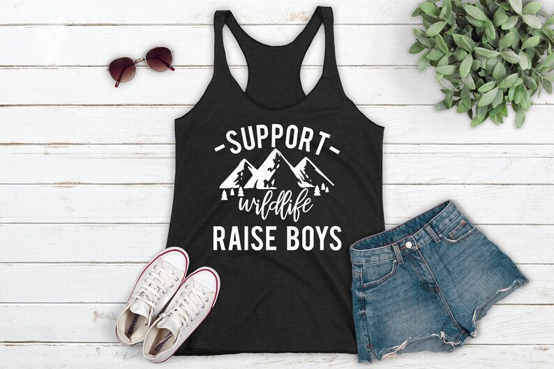 May include: A black tank top with a white graphic that says "Support wildlife raise boys" with a mountain range design.